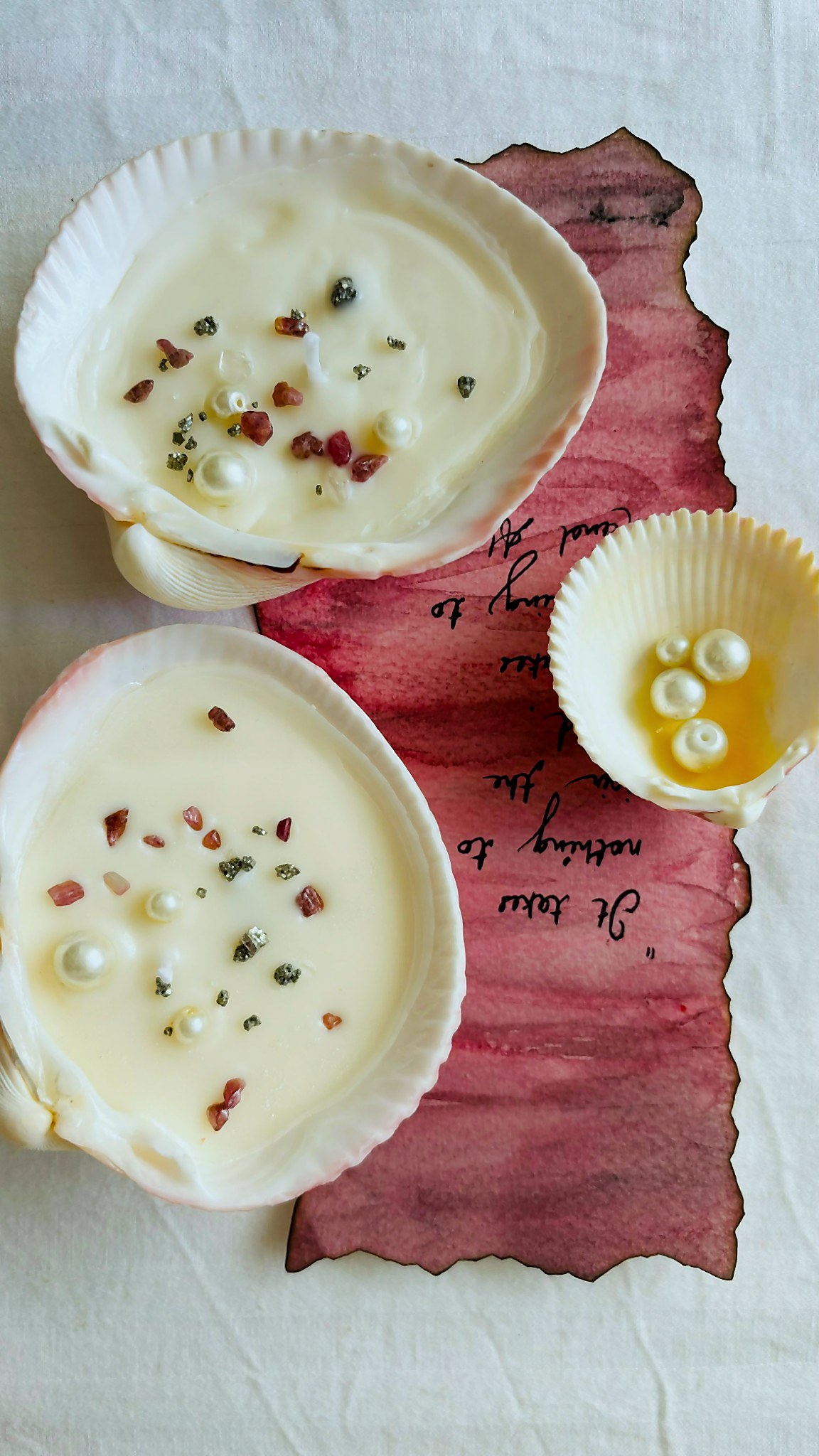 Two shell-shaped soy candles on a hand-painted pink leaf
